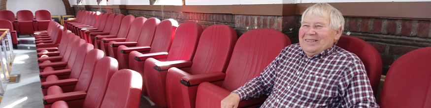 Gentleman relaxes in a red leather chair